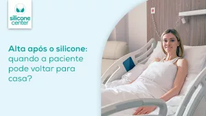 Alta após o silicone: quando a paciente pode voltar para casa? Imagem de uma mulher deita em uma capa hospitalar dentro do quarto do hospital