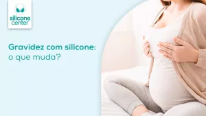 Gravidez com silicone: o que muda após a mamoplastia de aumento? Imagem de uma mulher sentada na cama, gravidez, segurando os seios