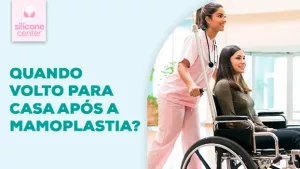 Alta da mamoplastia: quando a paciente volta para casa? Imagem mostrando uma moça sentada em uma cadeira de rodas, com uma outra mulher vestida de enfermeira conduzindo-a
